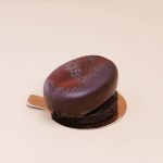 Prăjitură în formă de bob de cafea, cu blat de cacao și mousse cremos de cafea, un desert fin și aromat pentru iubitorii gustului intens de cafea.